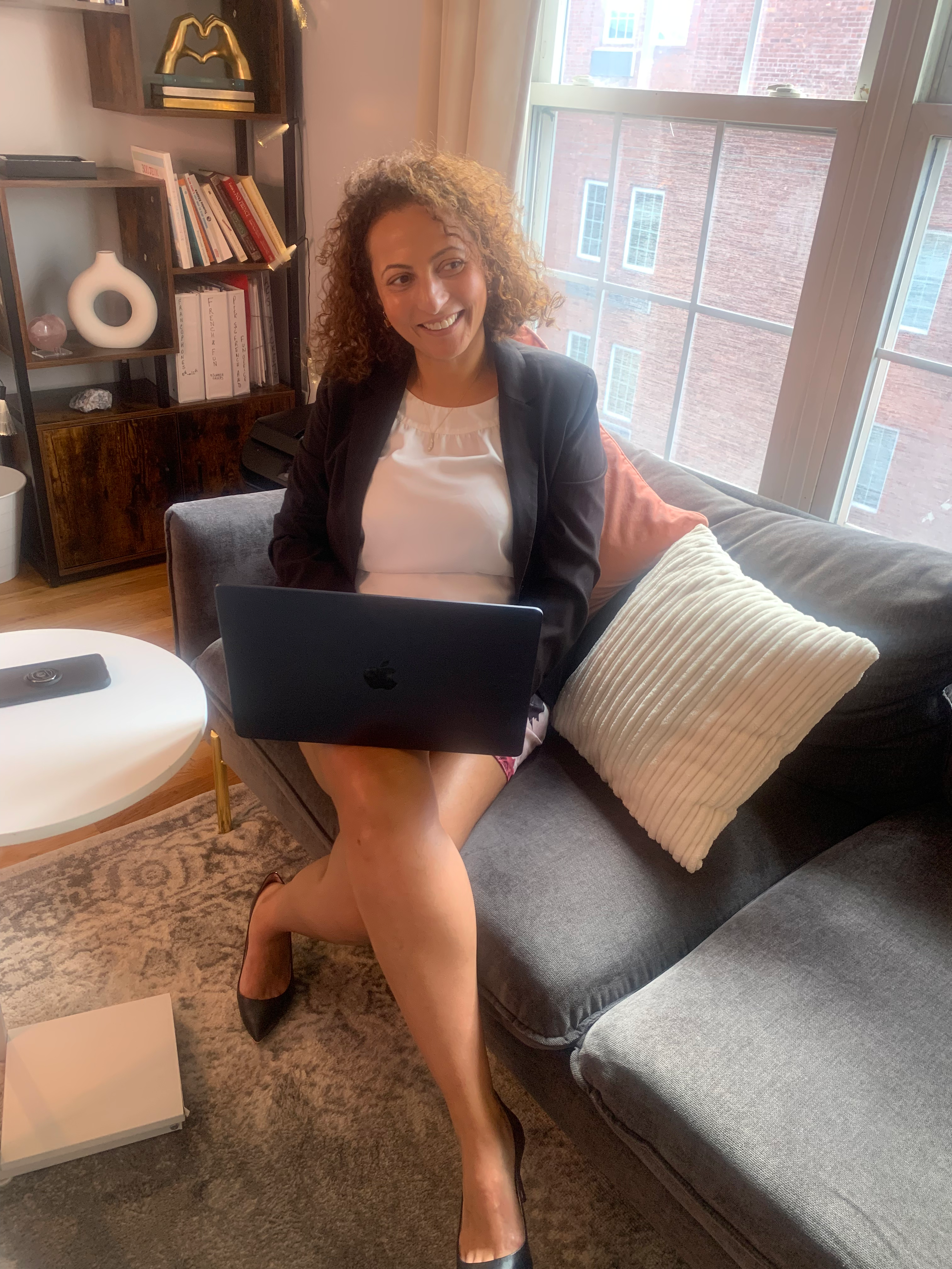 Ria Aichour, alignment coach, sitting in session with her laptop