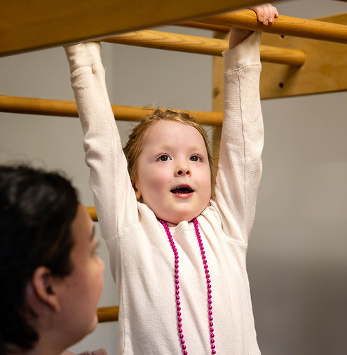 Therapist supporting a child during a therapy activity