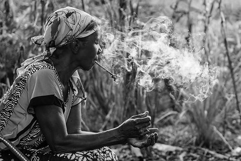 Uma mulher fumando cigarro com fumaça, em preto e branco, Geral.
