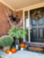 fall front porch with mums, pumpkins and giant spiders