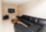 Basement tv and sofa in long space
