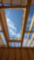View of the sky through a partially constructed wooden roof.