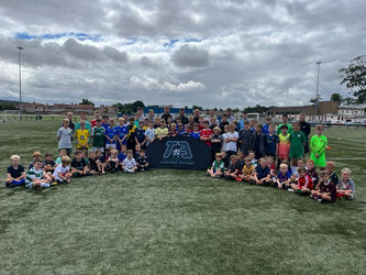 Group of young football players posing with the logo for TA Training Academy