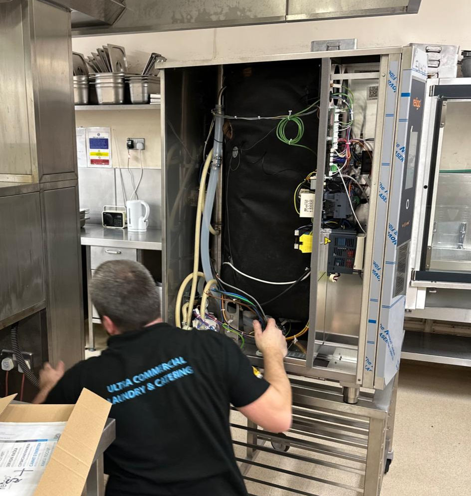 Technician repairing industrial oven, Maintenance & Repair, with exposed wires and components