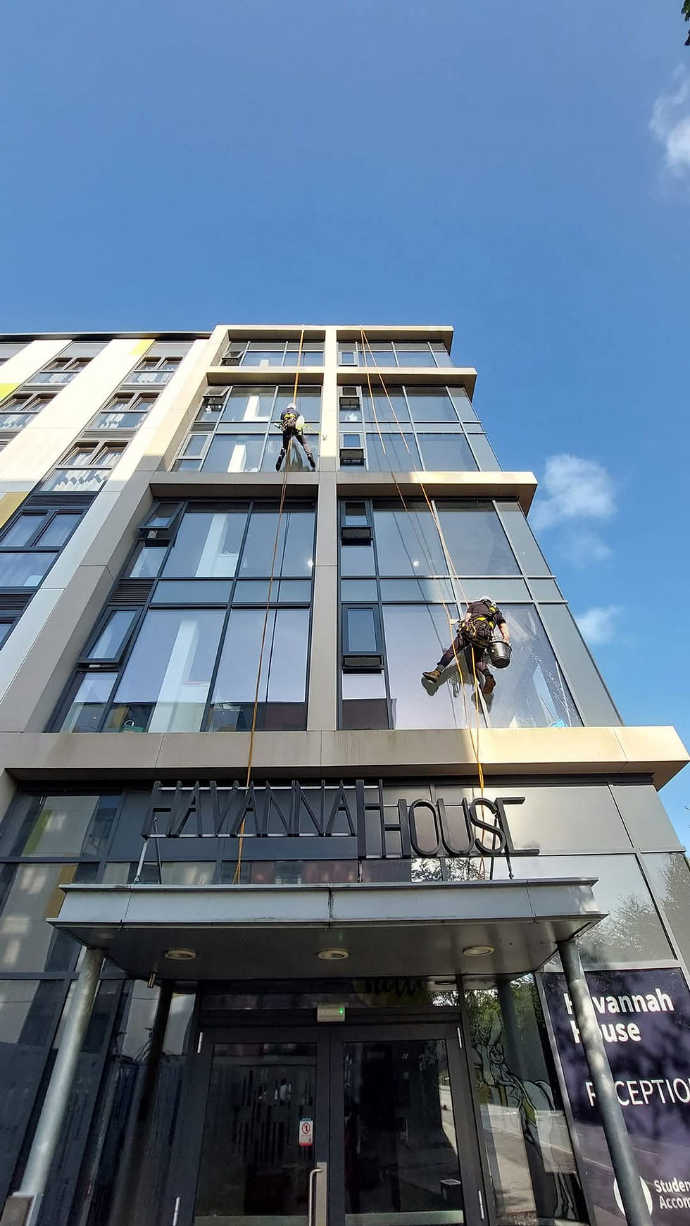 Rope access technicians abseiling a glazed office façade in Edinburgh