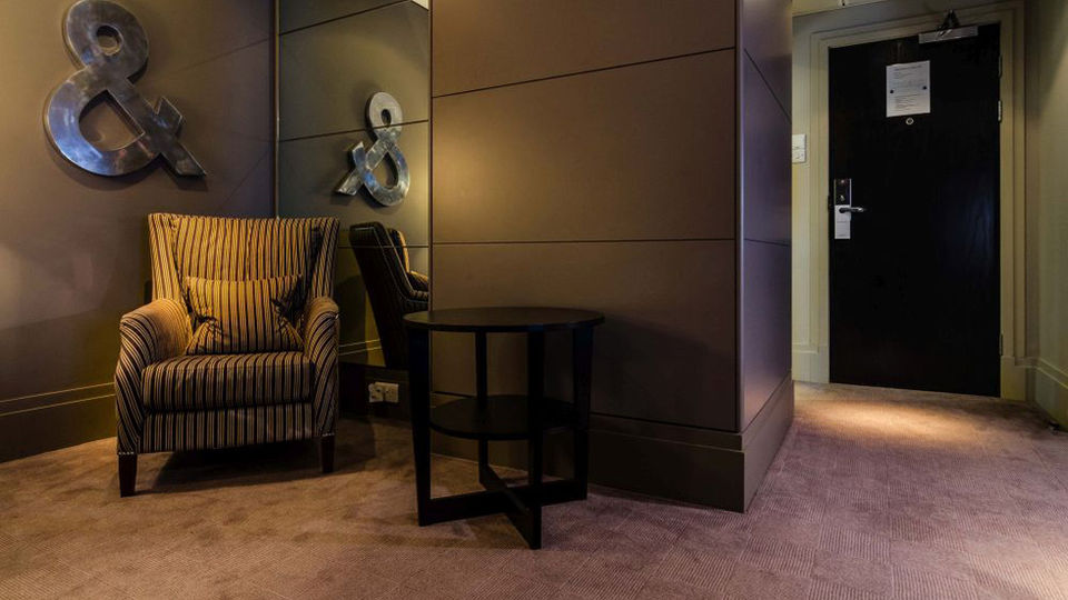 Cozy armchair and table in a dimly lit hallway.