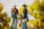 Director Raen LeVell giving direction to an actor in Western period costume on location.