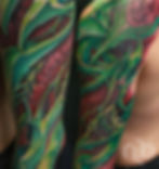 green and red bio organic sleeve tattoo inspired by parrot bird colors and shapes.