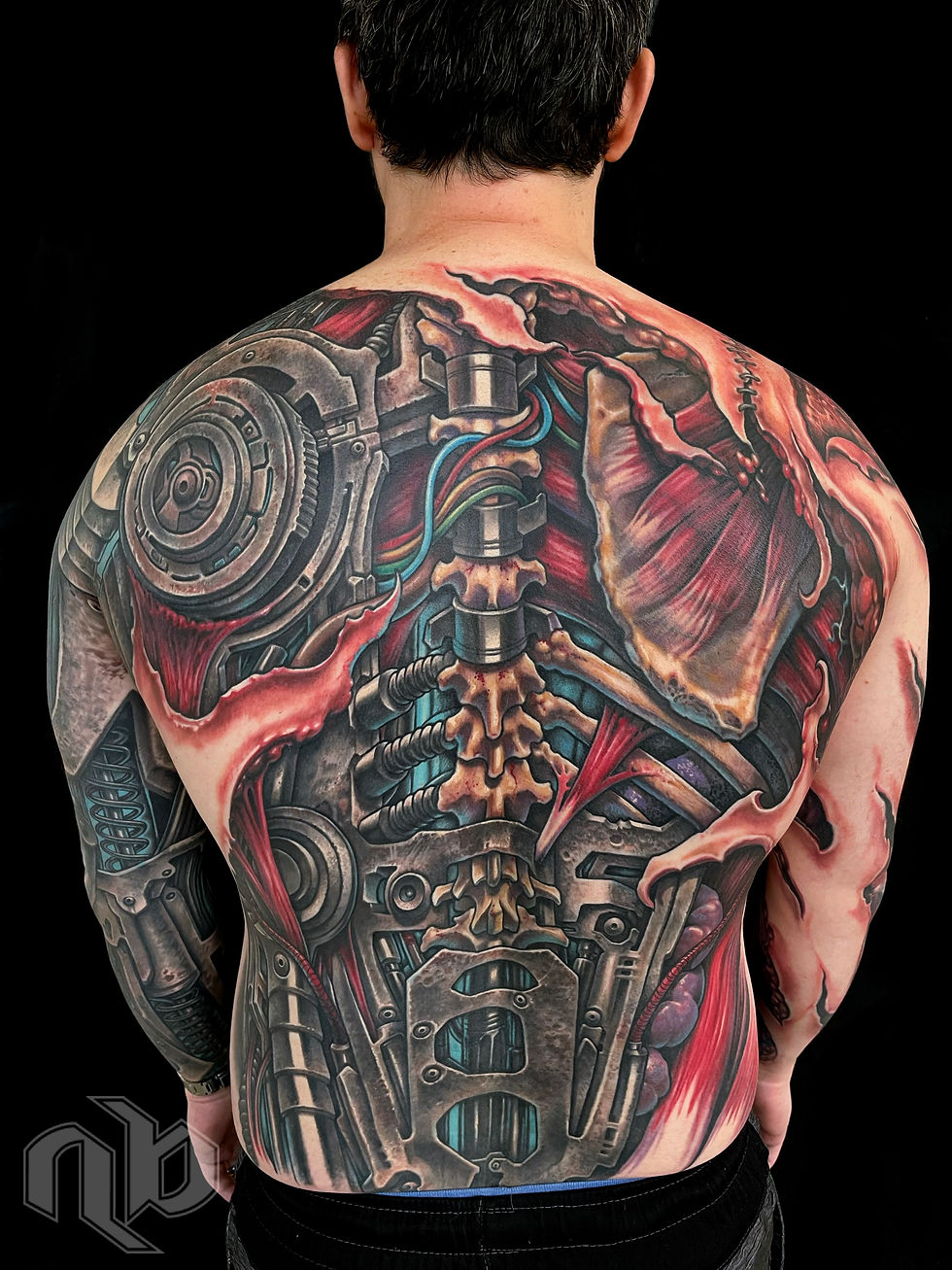 color biomechanical back and chest tattoo of exposed human anatomy and organs being replaced with weathered and damaged robot machinery by nick baxter in austin texas