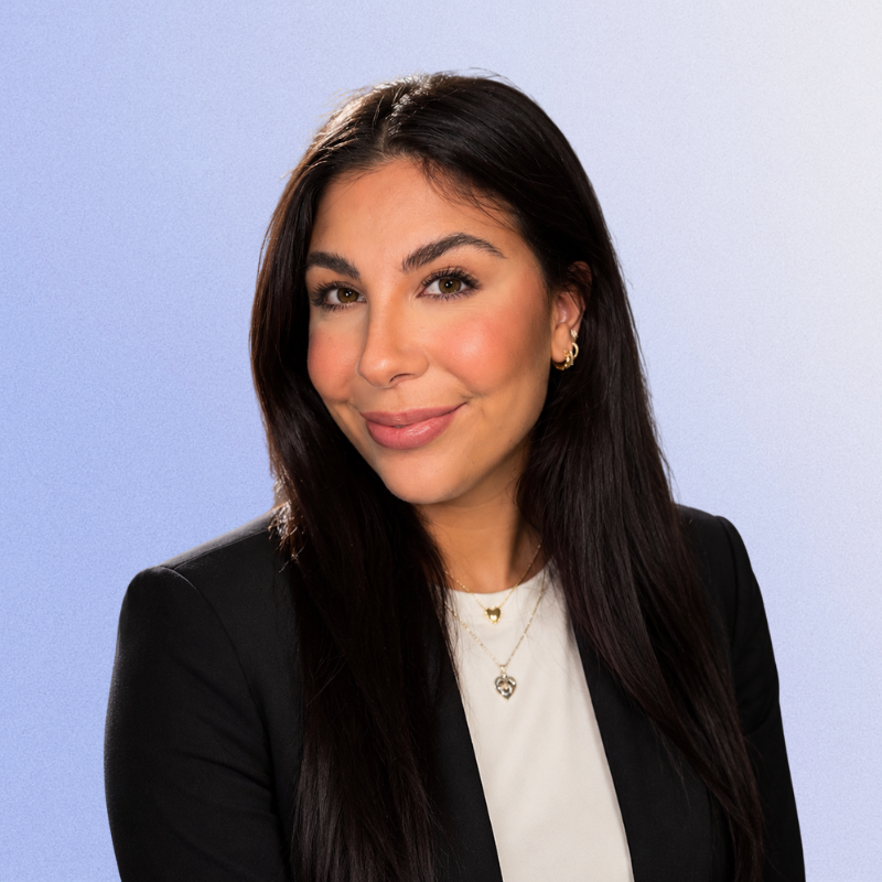 Professional headshot of a smiling woman with long dark hair