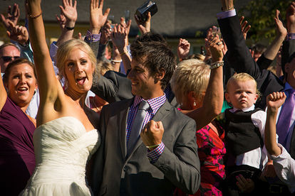 Bride and groom celebrating with guests outdoors as the DJ cues the next track at a Christchurch wedding.