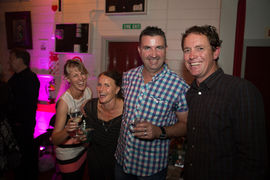 Smiling guests posing for a photo with the DJ at a Christchurch event.