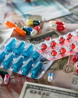 Various pills laying on different countries money