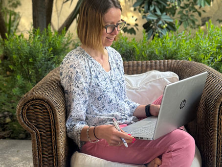 Dr Gemma photographed sitting in a wicker chair during a coaching call on her laptop