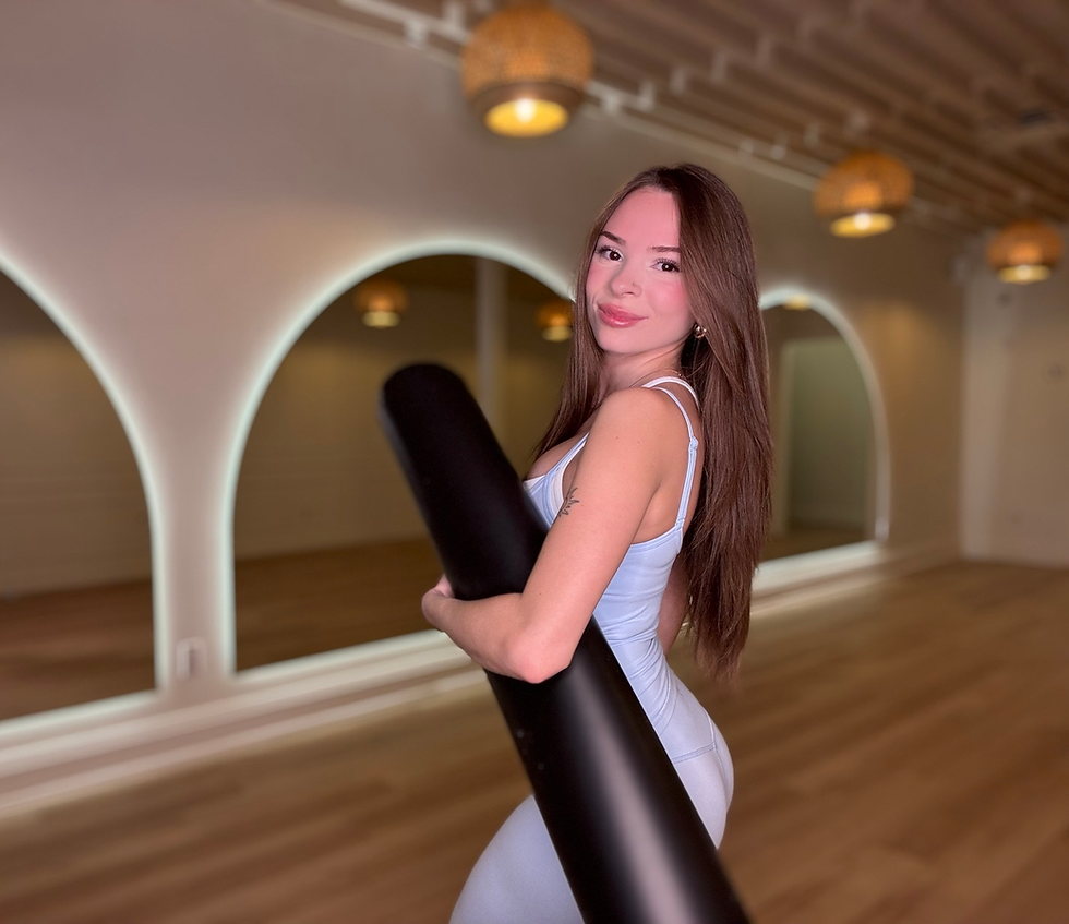 Woman holding a yoga mat in our stunning boutique yoga studio.