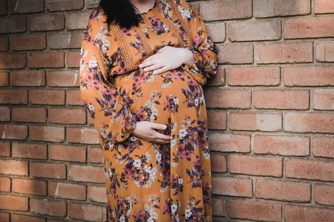maternity photoshoot - pregnant belly in floral orange dress