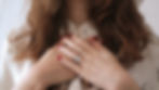 A closeup of a woman with her hands over her heart