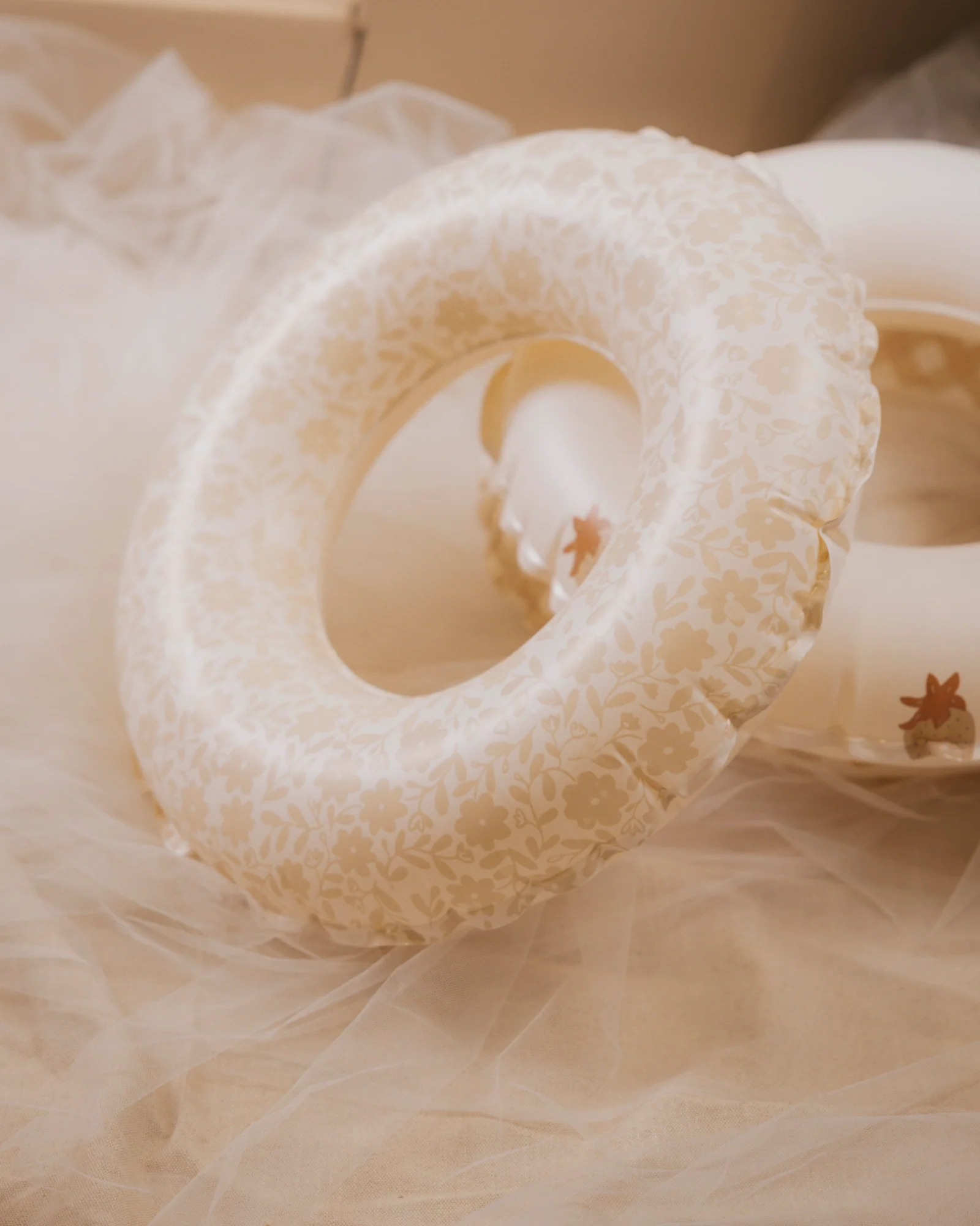 A studio picture of a neutral floral inflatable ring
