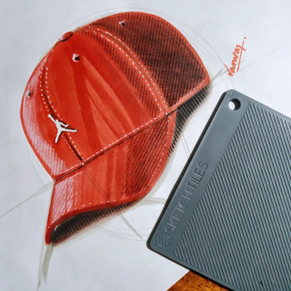 Red baseball cap with white Jumpman logo, SketchTiles brand, drawing on paper