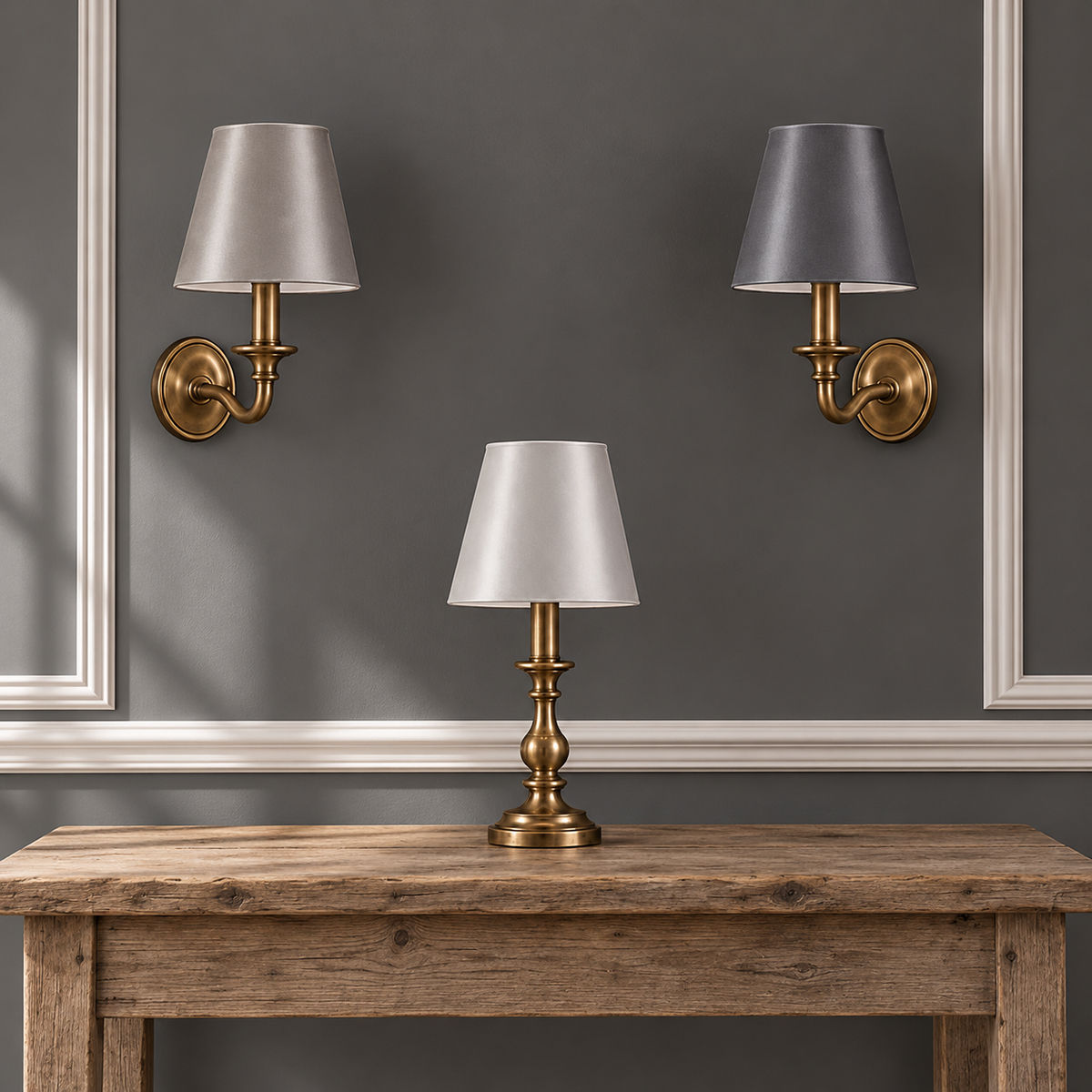 Silky Silver, Pewter and Dark Grey satin candle clip lampshades on brass fittings against a grey wall with white detailing.