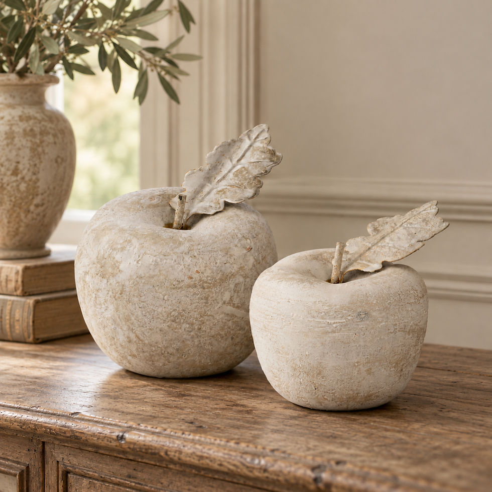 Large and small stone effect apple ornaments with decorative leaves styled together on a rustic console in a neutral heritage