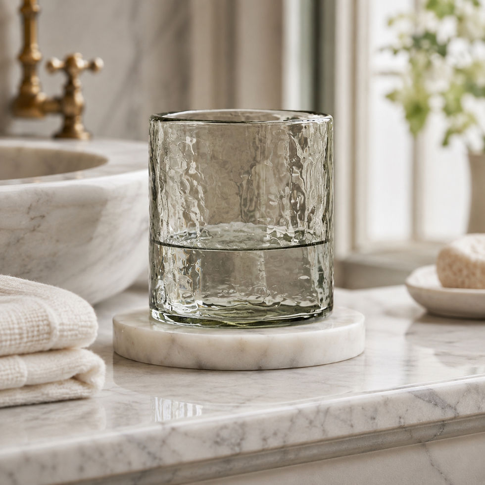 Hammered glass holder with marble base used as a refined bathroom tumbler.