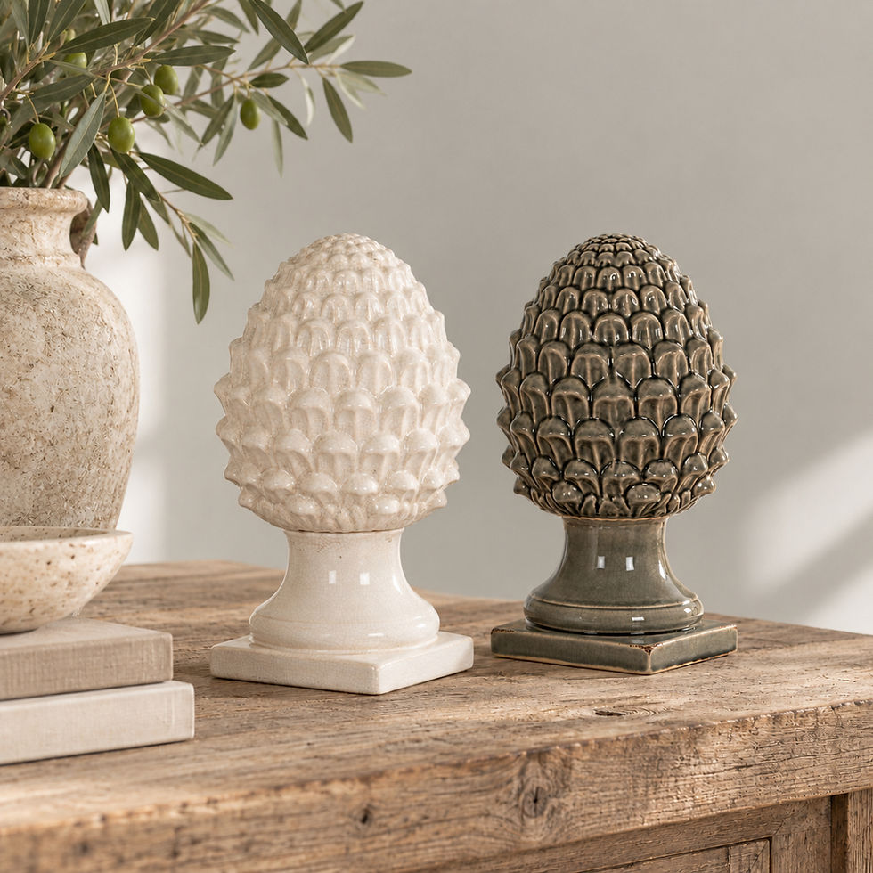 White and grey Garda decorative acorn ornaments styled together on a weathered wooden table against a light French grey wall