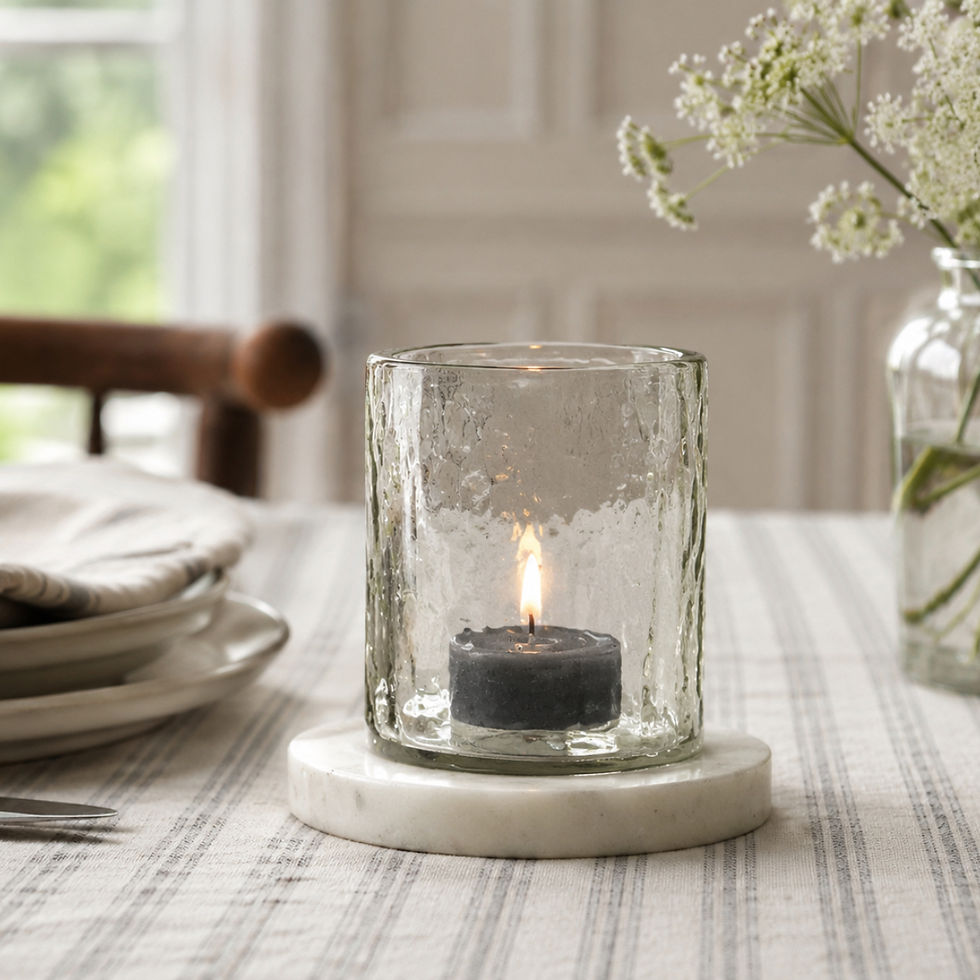 Hammered glass marble-base tea light holder styled with a deep grey candle for subtle contrast.