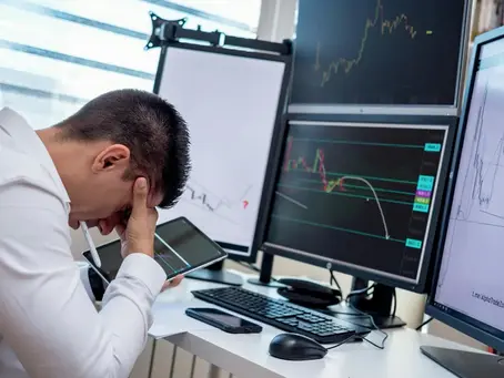 A trader suffering from Trading Drawdown and watching his trading screens