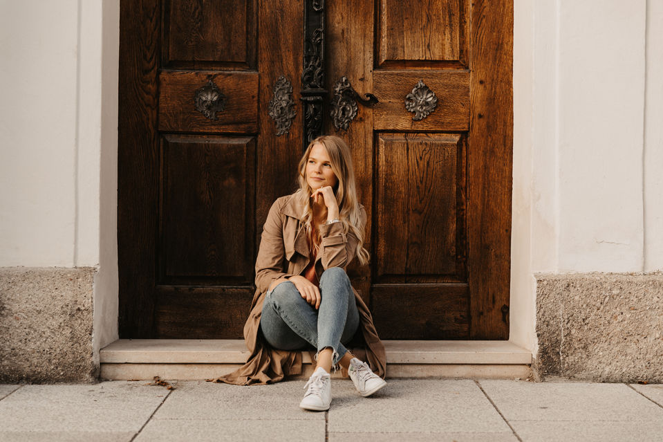 Frau sitzt auf dem Boden vor einer Tür