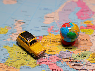A toy car and miniature globe on a world map