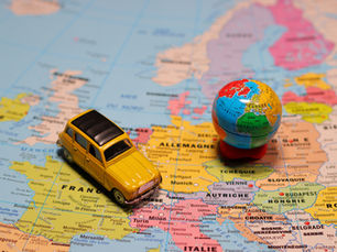 A toy car and miniature globe on a world map