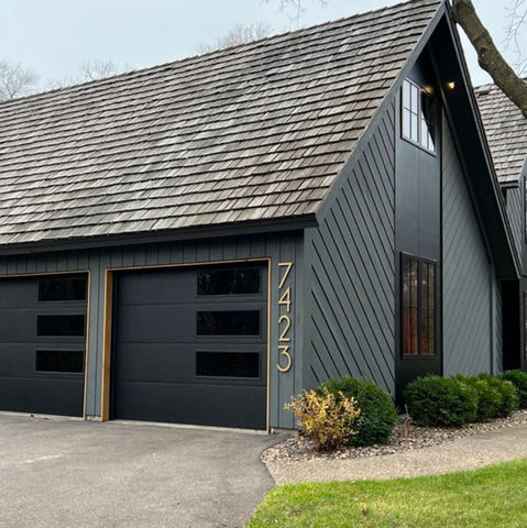Extra large metal house numbers mounted vertically beside garage on beautiful home