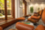 brown leather chairs facing windows with lots of sunlight
