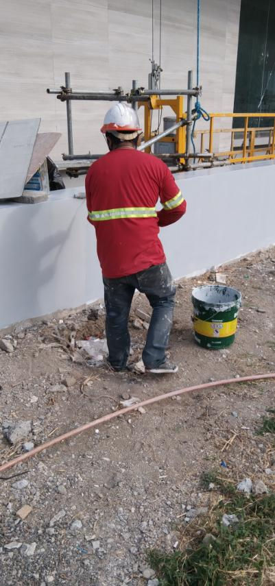 Worker painting exterior wall at Grass Residences site