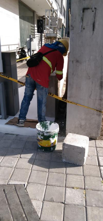 Worker in red jacket performing maintenance at Grass Residences.