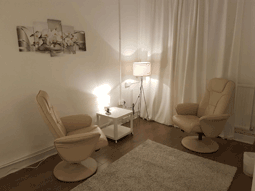 Colour photo of two cream leather chairs facing each other