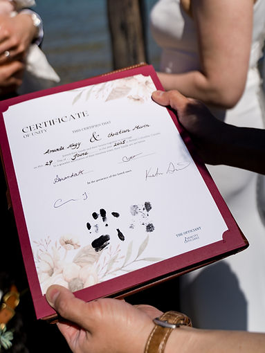 Close-up of a wedding unity certificate with a dog’s pawprint added as a symbolic keepsake during an officiant-led ceremony in Vancouver.