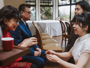 Bride serving tea to her mother during a Chinese tea ceremony, capturing a moment of acknowledgment and connection