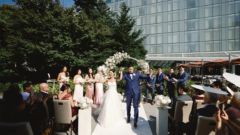 Signature Celebration wedding ceremony at JW Marriott Parq Vancouver in Downtown Vancouver with couple celebrating during the recessional.
