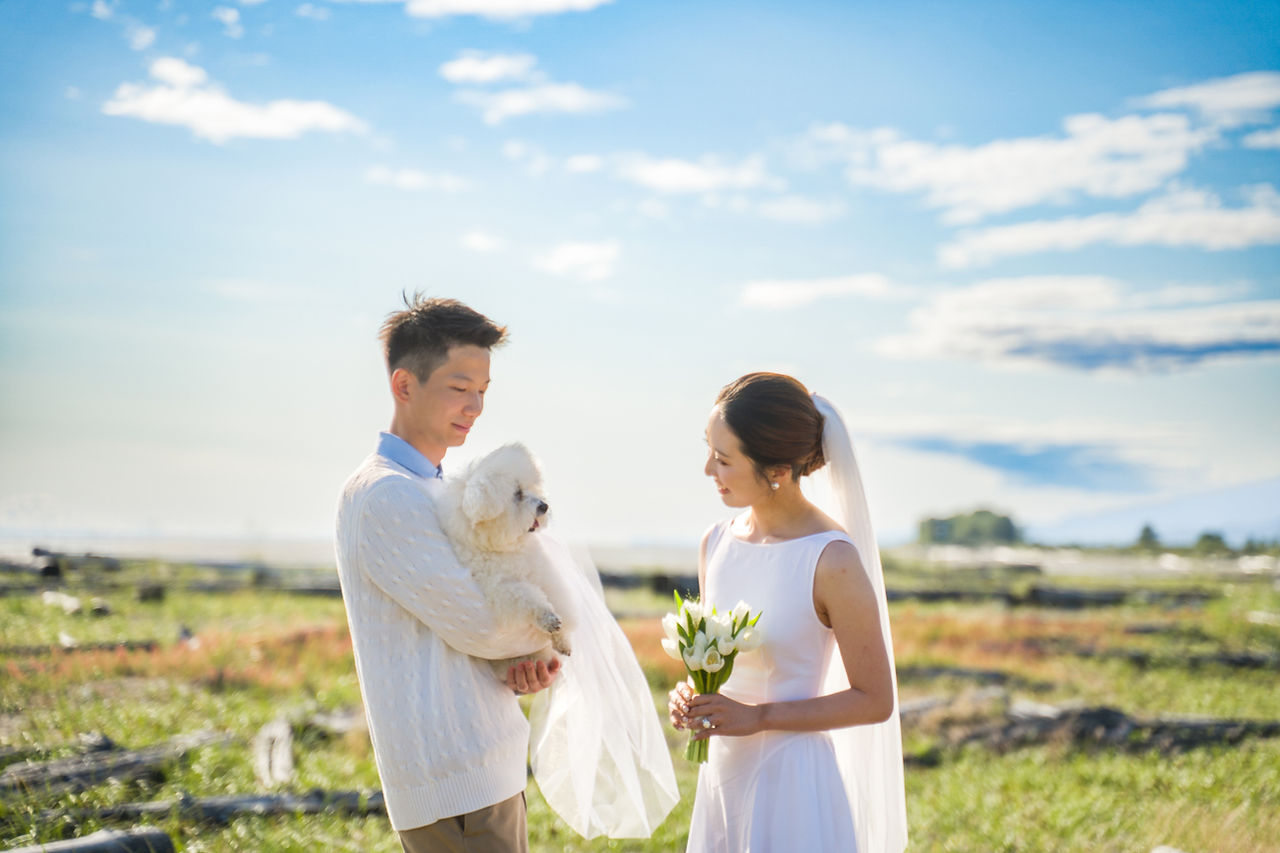 Couple standing together with their dog at Iona Beach during an intimate outdoor ceremony near Richmond, BC