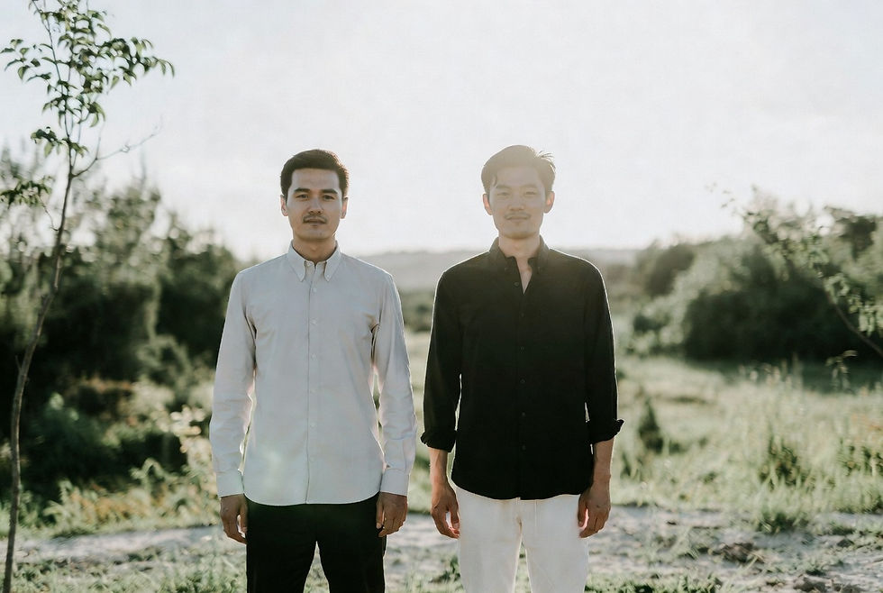 Two partners standing side by side outdoors in a quiet natural setting.