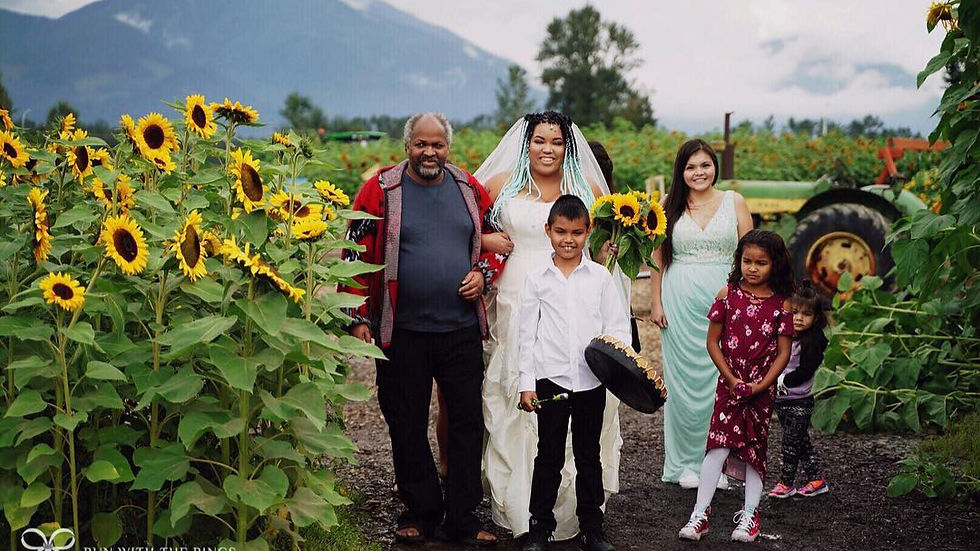 Family members participating in a First Nations elopement ceremony in a Chilliwack sunflower field