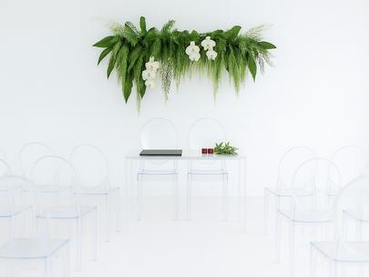 Minimalist indoor ceremony setup at The Ensora featuring a white signing table, transparent ghost chairs, and soft greenery accents, capturing the calm and sustainable atmosphere of the space before opening.