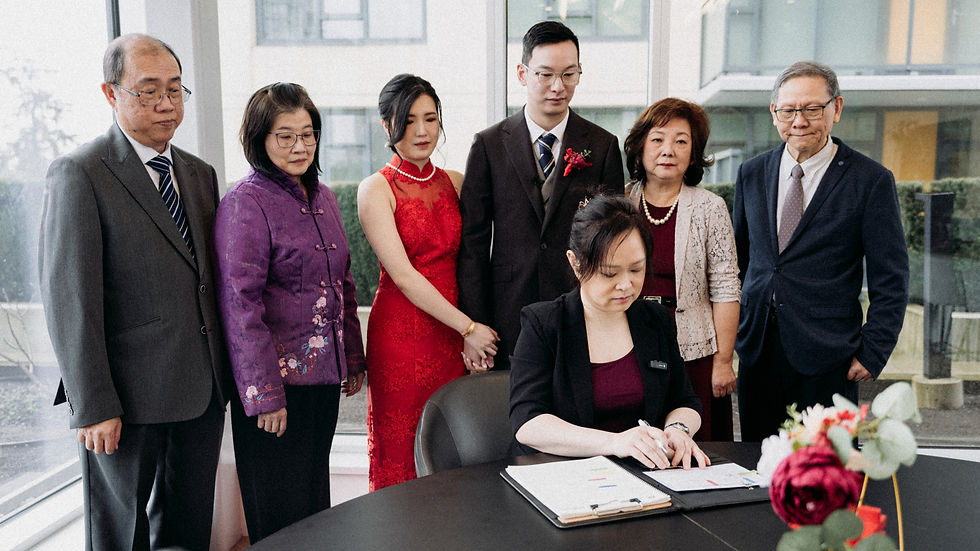 Couple signing their marriage licence with family members during a wedding ceremony in British Columbia.