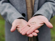 the ring warming moment couple holding wedding rings in hands before exchange ceremony
