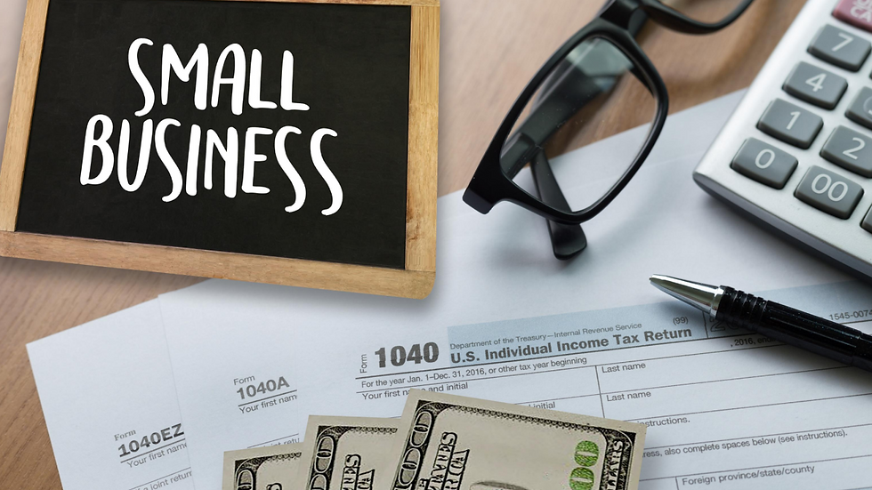 Tax forms, cash, glasses, and a pen are on a desk. A calculator is nearby. A small chalkboard with "SMALL BUSINESS" is also visible.