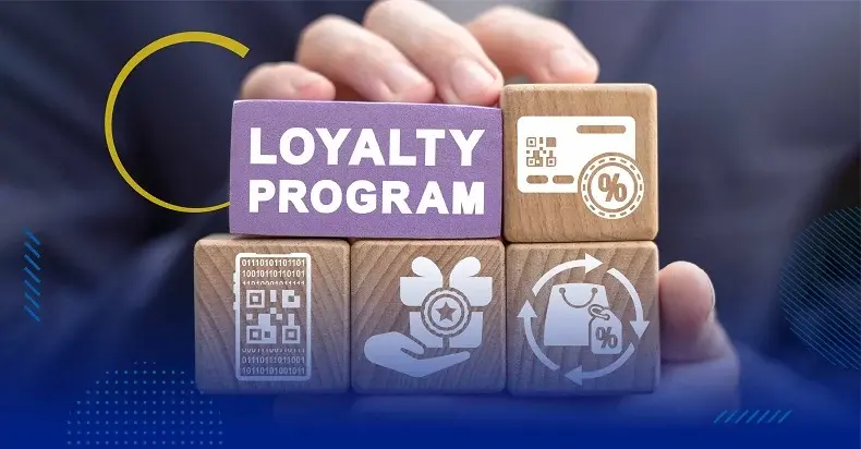 Hands hold wooden blocks with icons of shopping and rewards. The central block reads "LOYALTY PROGRAM" in bold white text on purple.