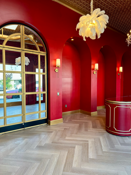 European-style red storefront studio in Burbank / North Hollywood featuring arched red walls, gold crystal and feather chande
