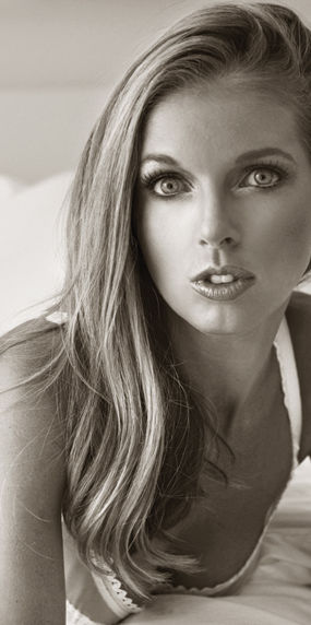 Blonde Sienna Sinclaire in a sensual pose, looking towards the camera. Sienna Sinclaire Studios